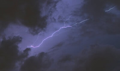 A lightning bolt illuminates a dark, cloudy sky during the relentless storm.
