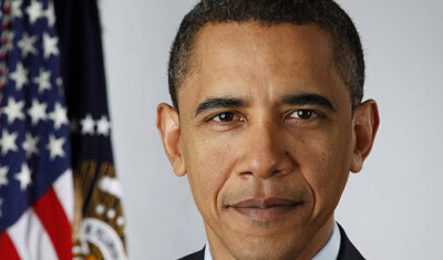 A person in a suit stands in front of an American flag, looking directly at the camera during the State of the Union.