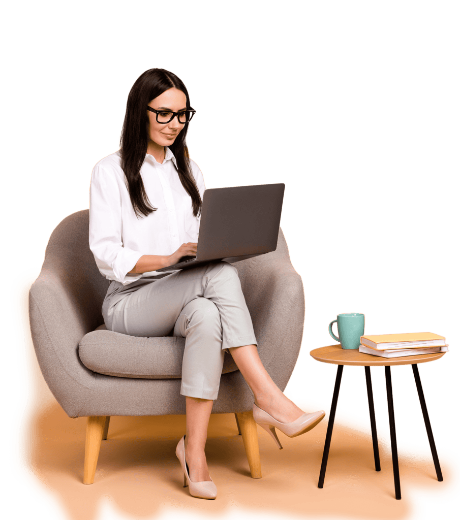 A person with long hair and glasses sits in an armchair using a laptop, likely immersed in freelance work. A small table next to them holds a coffee mug and two books.